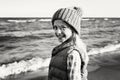 Caucasian child kid girl with long hair wearing jacket gilet and hat on beach at sunset Royalty Free Stock Photo