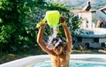 Caucasian child playing with water in an inflatable pool in the home garden at summer evening Royalty Free Stock Photo