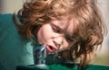 Caucasian child portrait drinking water outdoor in park close up. Kids in summer nature park. Thirsty kids.