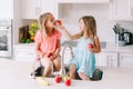 Caucasian children girls eating sharing fresh fruits sitting in kitchen sink. Happy family sisters siblings having snack. Organic