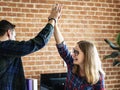 Caucasian colleagues give each other high five