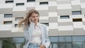 Caucasian Confident Young Business Woman in White Shirt is Talking on Phone Outside near Modern Office Building. Medium Royalty Free Stock Photo