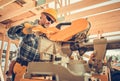 Contractor Worker Trimming Pieces of Wood Beams in a Construction Zone Royalty Free Stock Photo