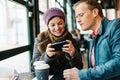 Caucasian couple in a cafe playing games on a smartphone