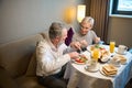 Caucasian couple cutting food during having breakfast and looking at each other Royalty Free Stock Photo