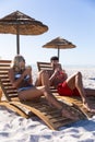 Caucasian couple sitting on deck chairs at the beach Royalty Free Stock Photo