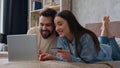 Caucasian couple happy woman and man looking at laptop screen on home bed excited smiling wife and husband pay money Royalty Free Stock Photo