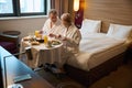 Caucasian couple having breakfast and looking at each other on bed at table Royalty Free Stock Photo