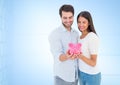 Caucasian couple holding a piggy bank together smiling against copy space on blue background Royalty Free Stock Photo