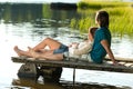 Caucasian couple lounging on pier sunset Royalty Free Stock Photo