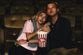 Caucasian couple lovers watching scary movie in theater with bucket of popcorn Royalty Free Stock Photo