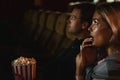 Caucasian couple lovers watching scary movie in theater with bucket of popcorn Royalty Free Stock Photo