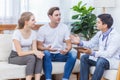 Caucasian couple patient husband and wife visit or meeting male doctor for pregnanct consultation at clinic or hospital. Lover Royalty Free Stock Photo