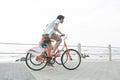 Caucasian couple riding bicycle on pavement near promenade at beach Royalty Free Stock Photo