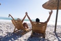 Caucasian couple sitting on deck chairs at the beach Royalty Free Stock Photo