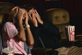 Caucasian couple wathing horror movie and putting hands cover face when having scary scene Royalty Free Stock Photo