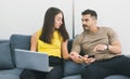 Caucasian couple working on laptop and smartphone