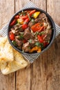 Caucasian cuisine Buglama lamb stewed with vegetables and herbs close-up in a bowl. vertical top view