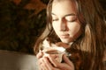 Girl sitting on the banch in a night park and taking a tea cup. Royalty Free Stock Photo