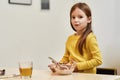 Favorite food. Caucasian cute little girl looking at camera while eating cereal balls with milk for her breakfast or Royalty Free Stock Photo