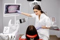 Caucasian dentist woman explaining xray on screen to female patient at clinic Royalty Free Stock Photo