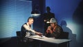 Caucasian detectives giving suspected black guy a glass of water in interrogation room