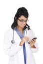 Caucasian woman doctor wearing a lab coat and entering data into a PDA Royalty Free Stock Photo