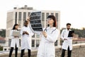 Caucasian doctor holding x-ray scan of patient during break outdoors hospital. Royalty Free Stock Photo