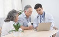 Caucasian doctor use laptop and talk with old asian male patient about disease symptom, elderly health check up at home