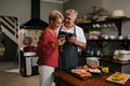 Caucasian elderly couple embracing while cooking in kitchen Royalty Free Stock Photo