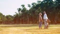 The Caucasian elderly couples standing beside a bicycle in the natural autumn sunlight garden and turn them face toward to camera