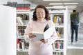 Caucasian elderly woman reading a book in a public library Royalty Free Stock Photo