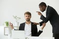 Caucasian employee meditating at workplace ignoring angry boss s Royalty Free Stock Photo