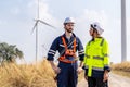 Caucasian engineer man discuss together with co-worker woman and stay in front of row of windmill or wind turbine with sky Royalty Free Stock Photo