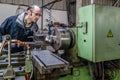 Caucasian engineer watching the headstock of turning lathe machine in factory