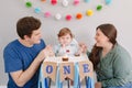 Caucasian family with baby boy celebrating first birthday at home. Proud parents mother and father dad together with child kid Royalty Free Stock Photo