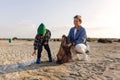 Caucasian family is collecting plastic waste on beach. Mother is teaching her son to help keep nature clean Royalty Free Stock Photo