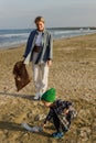 Caucasian family is collecting plastic waste on beach. Mother is teaching her son to help keep nature clean Royalty Free Stock Photo