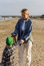 Caucasian family is collecting plastic waste on beach. Mother is teaching her son to help keep nature clean Royalty Free Stock Photo