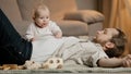 Caucasian family father with little daughter son lie on floor at home play. Baby girl boy newborn kid crawling over Royalty Free Stock Photo