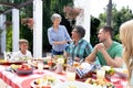 Caucasian family sitting at table during a family lunch in the garden Royalty Free Stock Photo