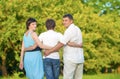 Caucasian Family of Three Spending Time Together Embraced in Summer Park.Horizontal Image