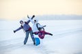 Caucasian family from three women standing with raising hands on lake, winter hiking