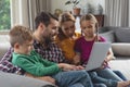 Caucasian family using laptop on the sofa in a comfortable home Royalty Free Stock Photo