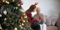 Caucasian Family, winter holiday and concept happy mother and daughter decorating Christmas tree and give a gift at home Royalty Free Stock Photo