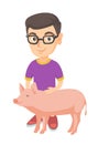 Caucasian farmer boy in glasses stroking a pig. Royalty Free Stock Photo