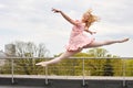 Caucasian fashion ballerina leaping on the roof