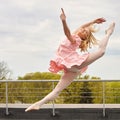 Caucasian fashion ballerina leaping on the roof