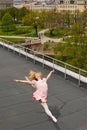 Caucasian fashion ballerina leaping on the roof