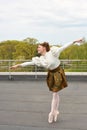 Caucasian fashion ballerina leaping on the roof